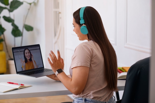 Foto gratuita donna che effettua una videochiamata utilizzando un dispositivo portatile da casa