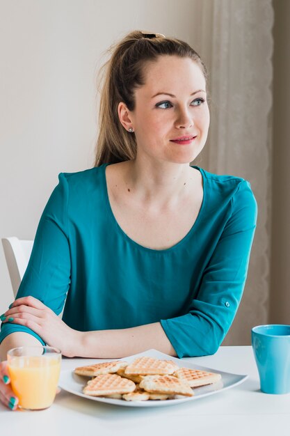 Woman having waffles and juice for breakfast