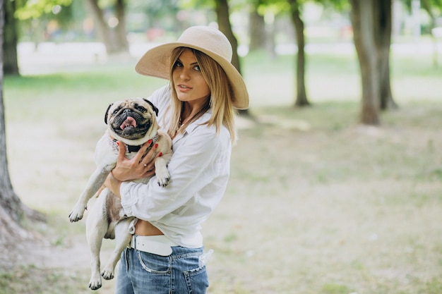 Free photo woman having a walk in park with her pug-dog pet