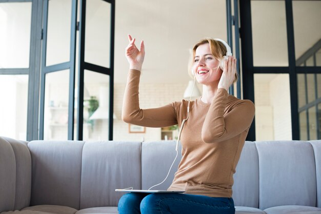 Woman in headphones listening to music and dancing 