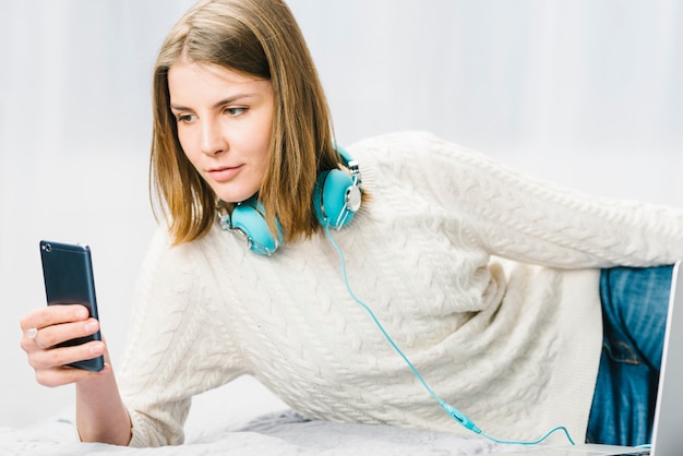 Woman in headphones using smartphone