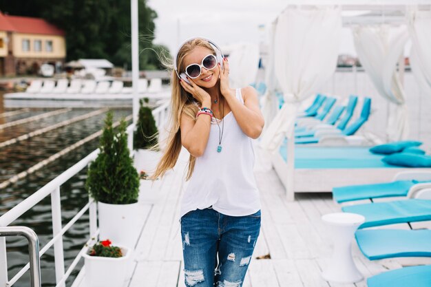 Woman in headphones walking on pier