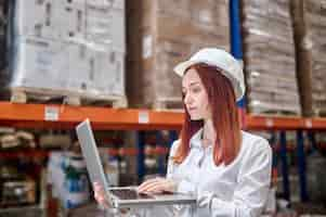 Free photo woman in helmet holding open laptop working