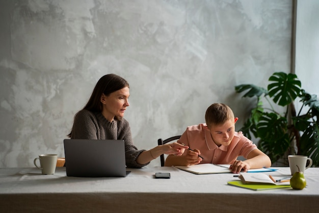 Woman helping boy with homework front view