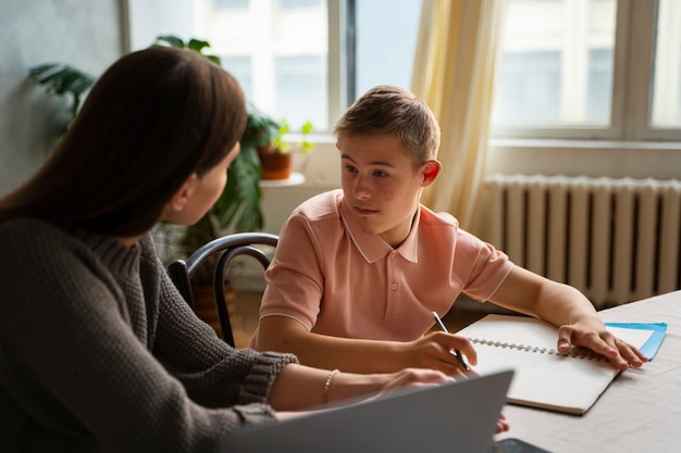 Free photo woman helping boy with homework side view