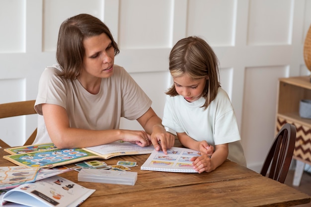 Free photo woman helping girl study medium shot