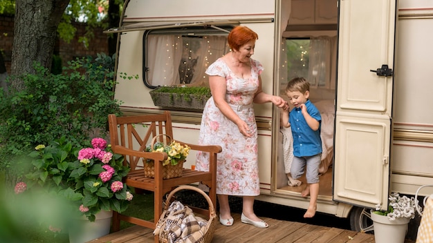 Woman helping her grandson to go down from a caravan