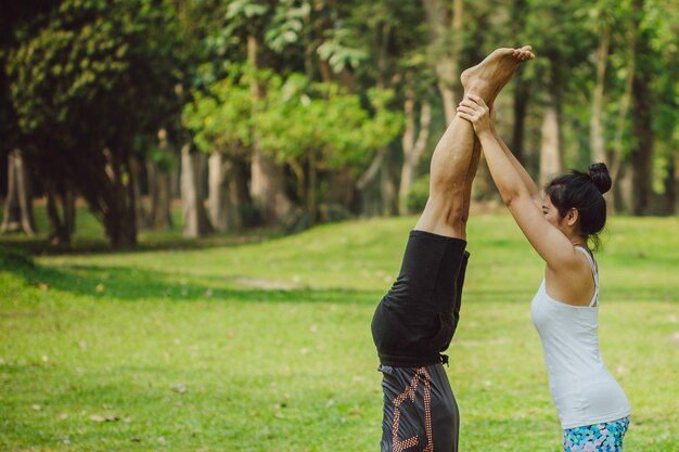 Woman helping her partner to handstand