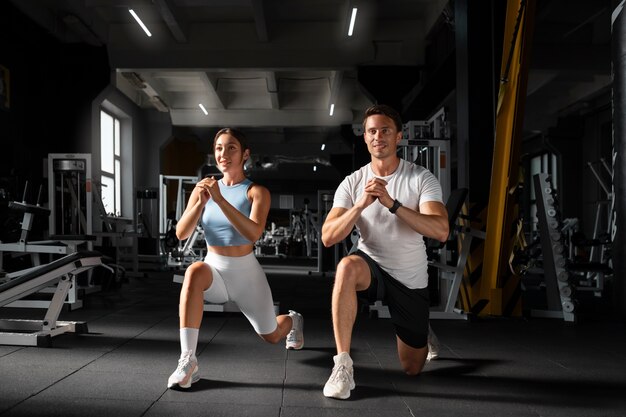 Woman helping man at gym