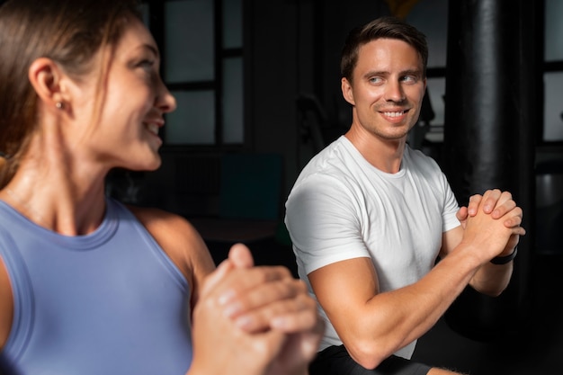 woman helping man at gym