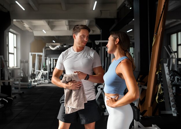 Woman helping man at gym