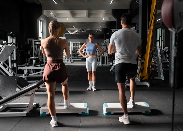 Woman helping man at gym