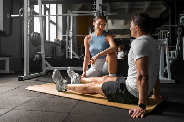 Woman helping man at gym