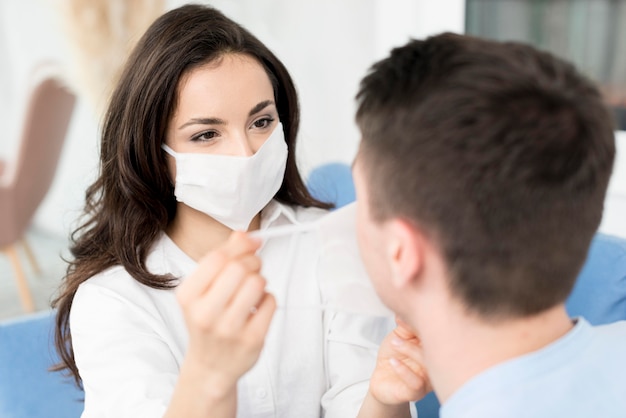 Foto gratuita l'uomo d'aiuto della donna ha messo sopra la maschera