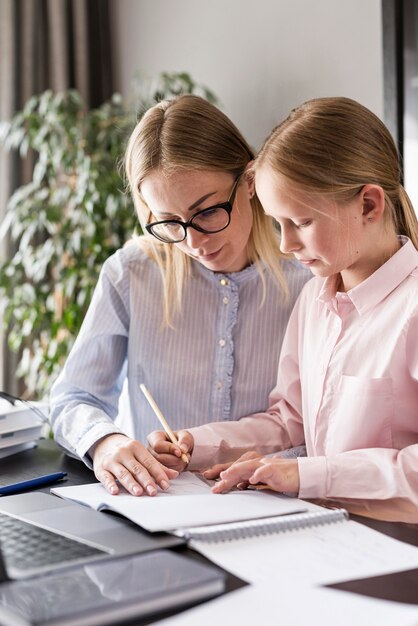 Woman helping young girl with homework