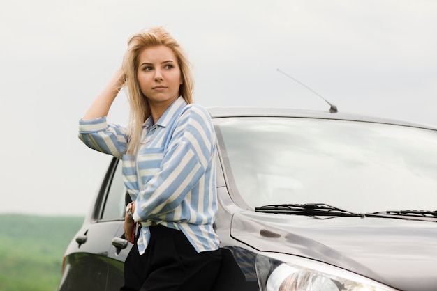 Foto gratuita donna accanto alla sua automobile analizzata