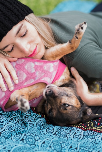 Woman and her dog lying on bed