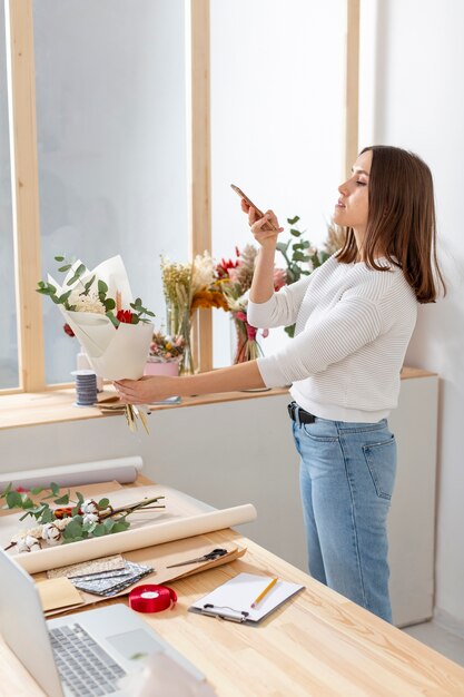 彼女の携帯電話を見て彼女のお花屋さんの女性