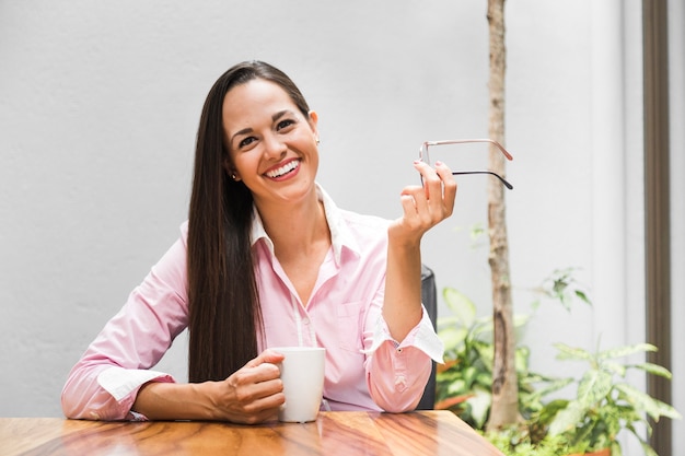 一杯のコーヒーと彼女のオフィスでの女性