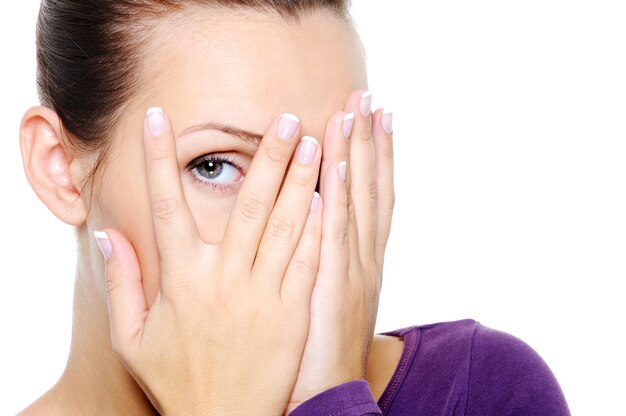 woman hide her face and watch through fingers