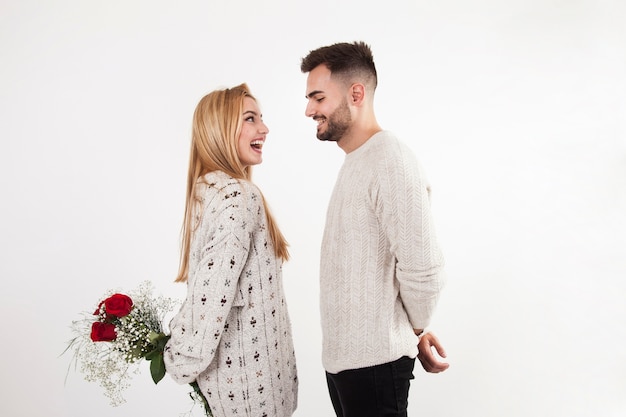 Woman hiding flowers from man