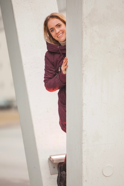 Woman hiding behind a pillar