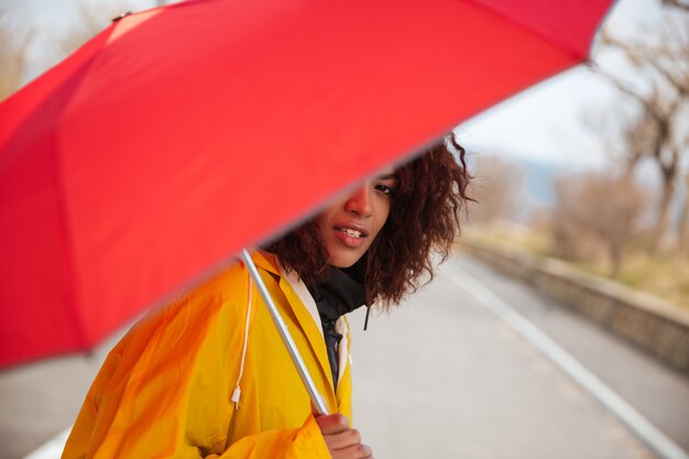 Woman hiding behind umbrella