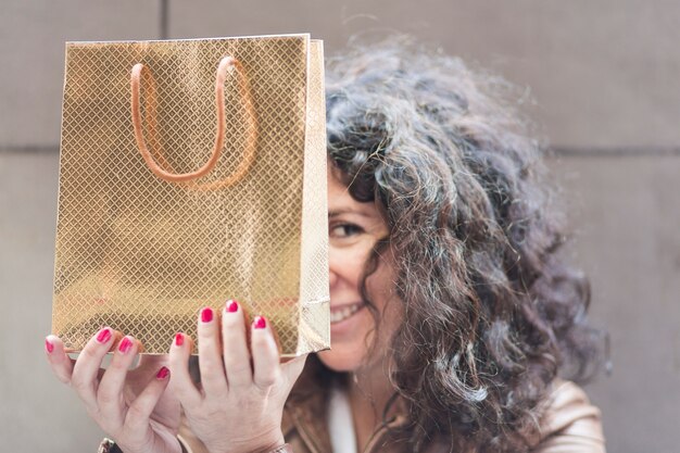 Foto gratuita donna che si nasconde con la borsa della spesa