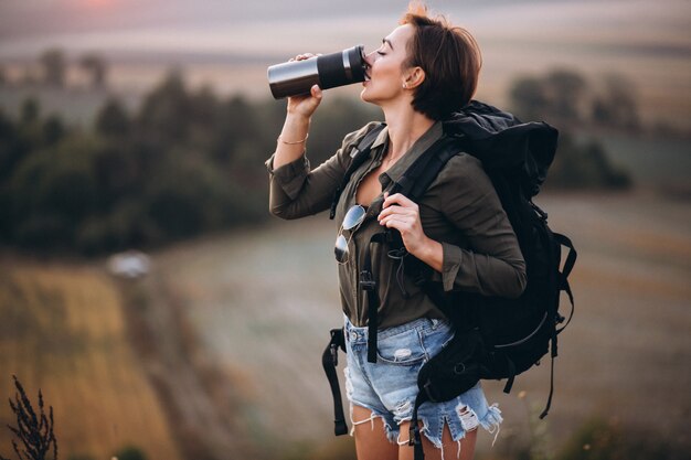 Woman hiking in the mountains and drinking water