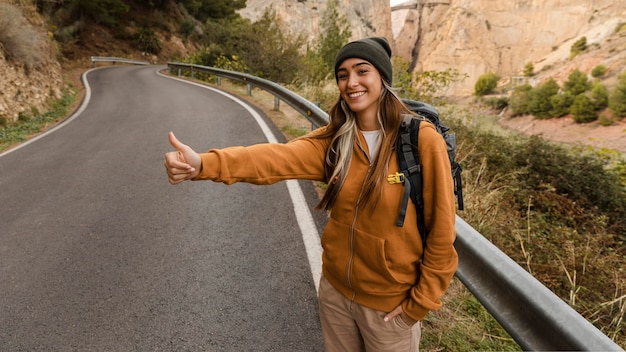 Free photo woman hitch-hiking for a car