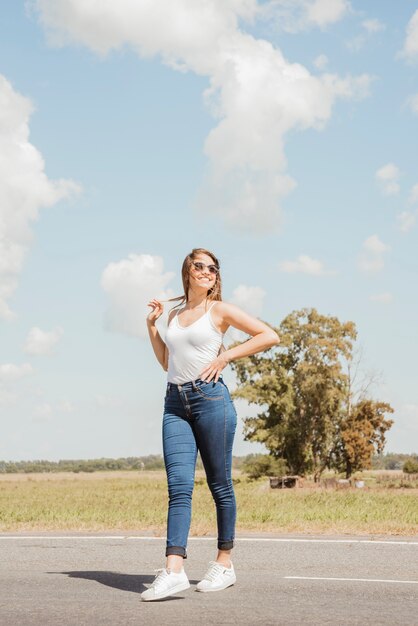 Woman hitchhiking on a road