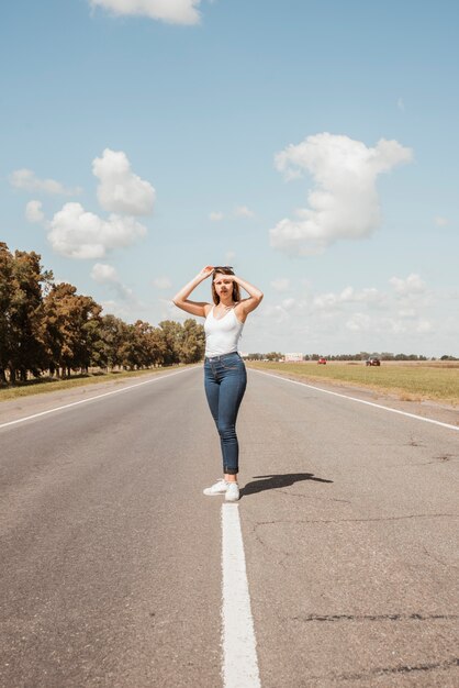 Woman hitchhiking on a road