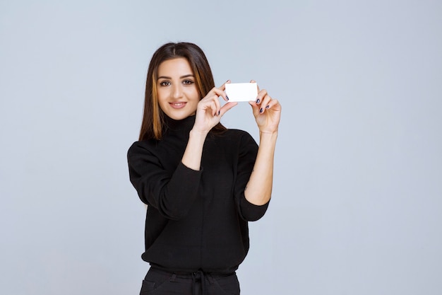 Бесплатное фото Женщина, держащая визитную карточку и представляясь.