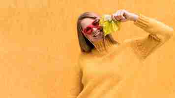 Free photo woman holding an autumn leaf