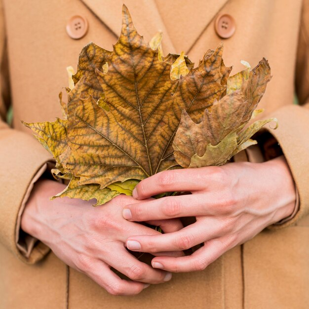 Woman holding autumn leaves