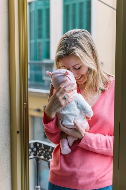 Free photo woman holding baby on balcony