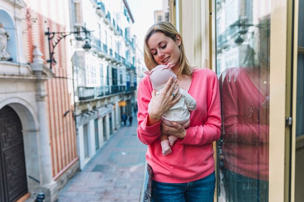 Woman holding baby on balcony