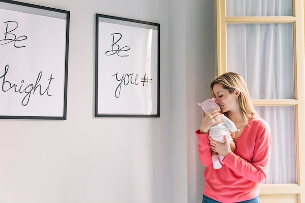 Woman holding baby and frames with quotes