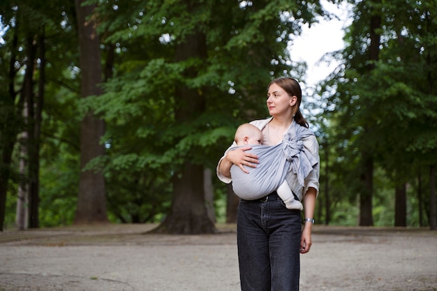 Женщина держит ребенка на открытом воздухе, вид спереди