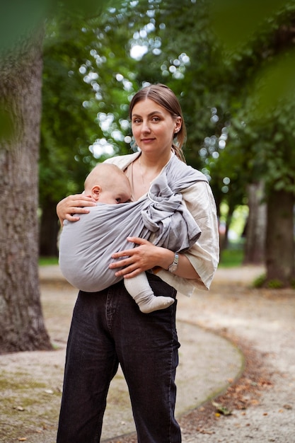 Woman holding baby outdoors front view