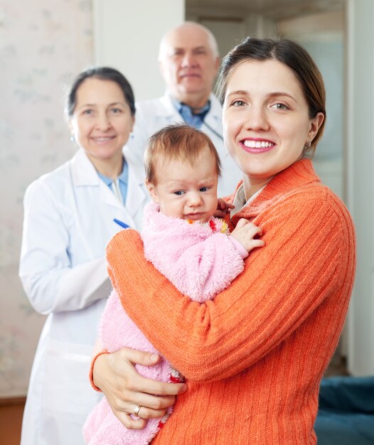 woman holding baby with doctors