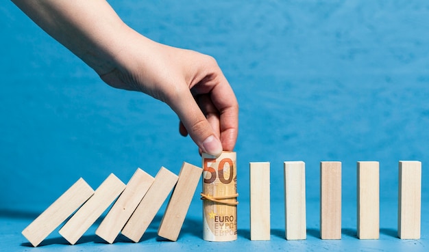 Woman holding bank-notes and fallen pieces of wood