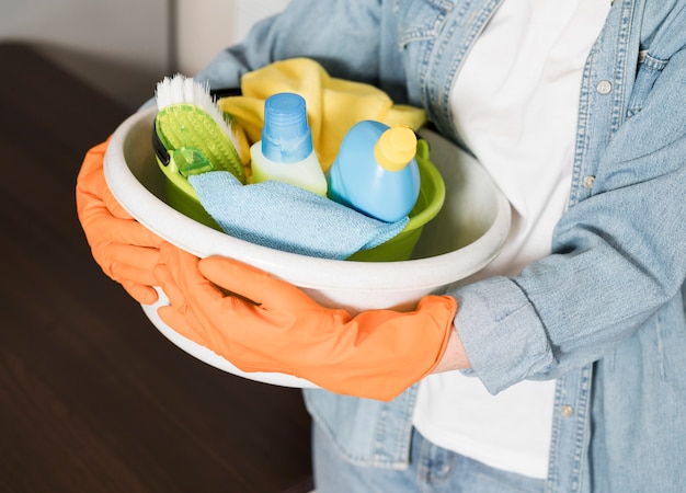 Woman holding basket of cleaning products