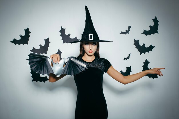 Женщина держит летучую мышь для Хэллоуина