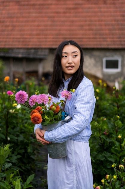 Foto gratuita donna che tiene bella vista laterale fiori