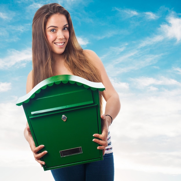 Woman holding a big green mailbox