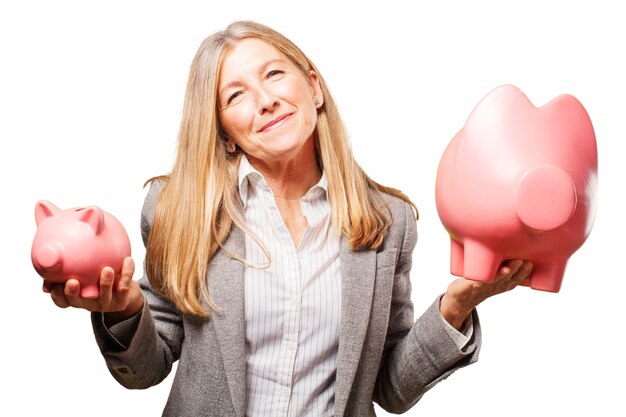 Woman holding a big pig piggy bank and a small piggy bank