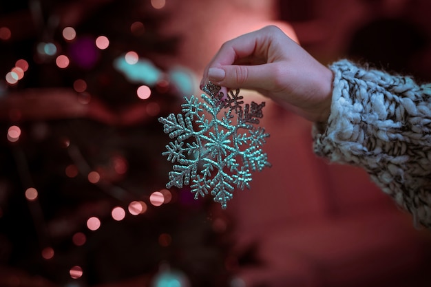 Free photo woman holding big snowflake in hand