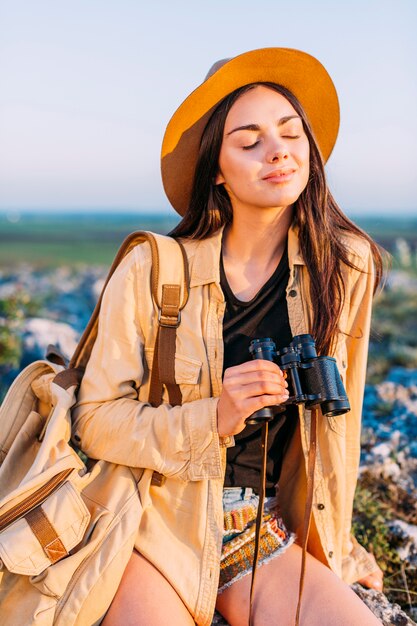 Woman holding binoculars with closed eyes