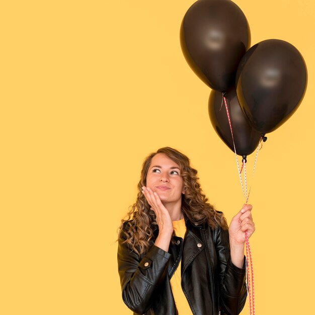 Woman holding black balloons